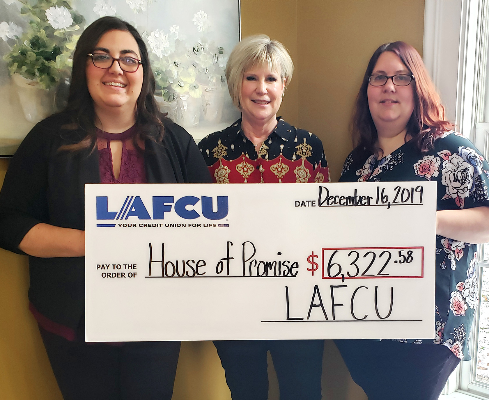 LAFCU-HouseofPromise.jpg – LAFCU's Amanda Seger, left, and Teri, right, present a check to Shari Montgomery of House of Promise in the amount of $6,322.50 from funds raised by LAFCU and its employees.